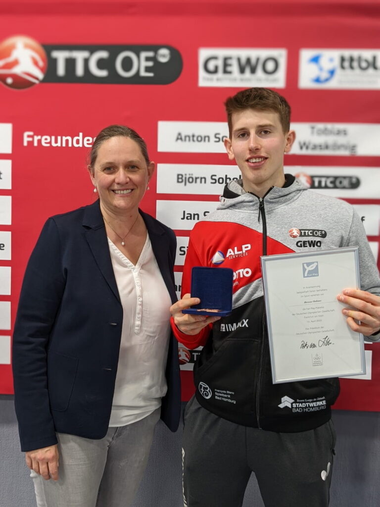 DOG-Mitarbeiterin Claudia Vatheuer überreicht die Fair Play Plakette Benno Oehme